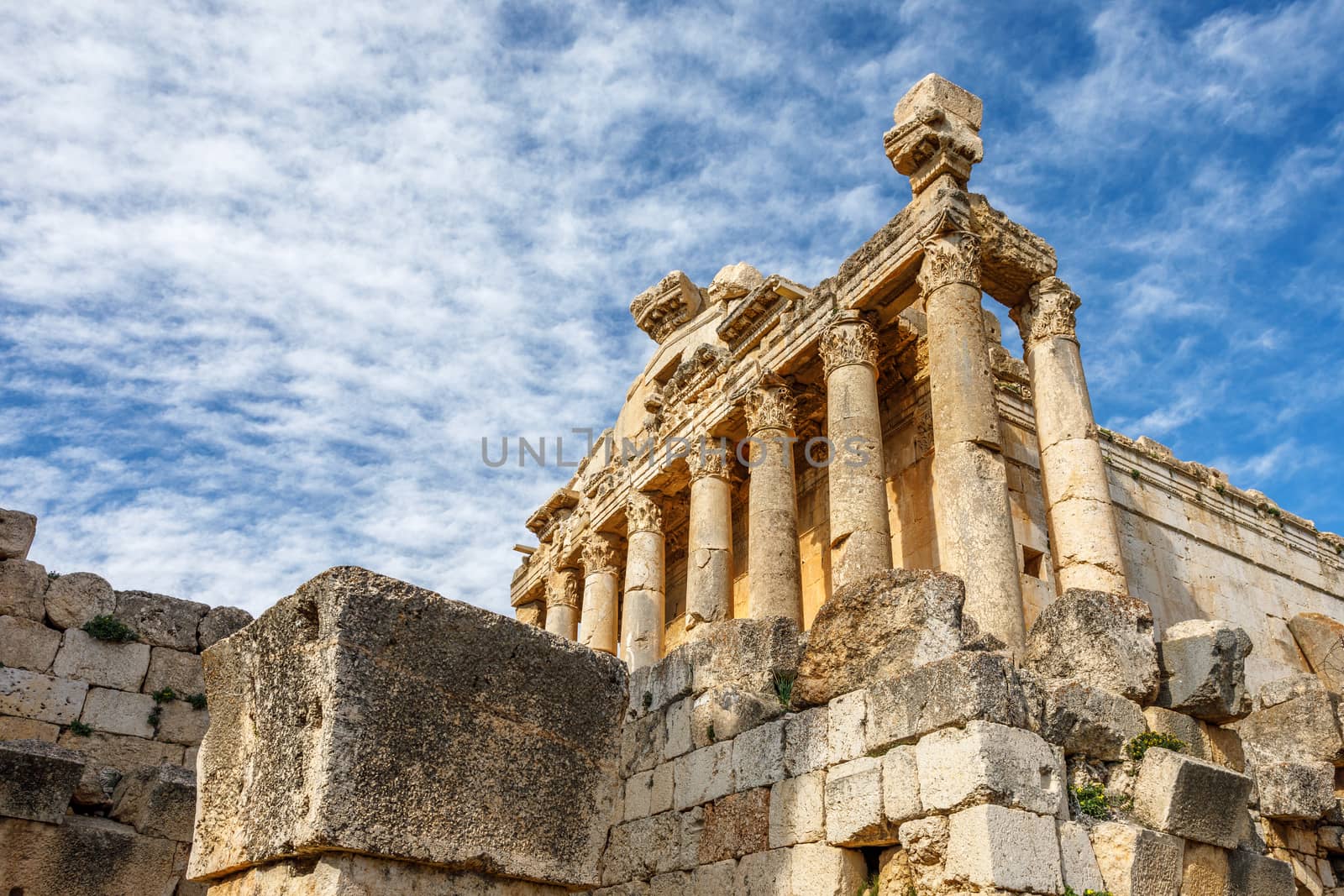 Columns of ancient Roman temple of Bacchus with surrounding ruins and blue sky in the background, Beqaa Valley, Baalbeck, Lebanon