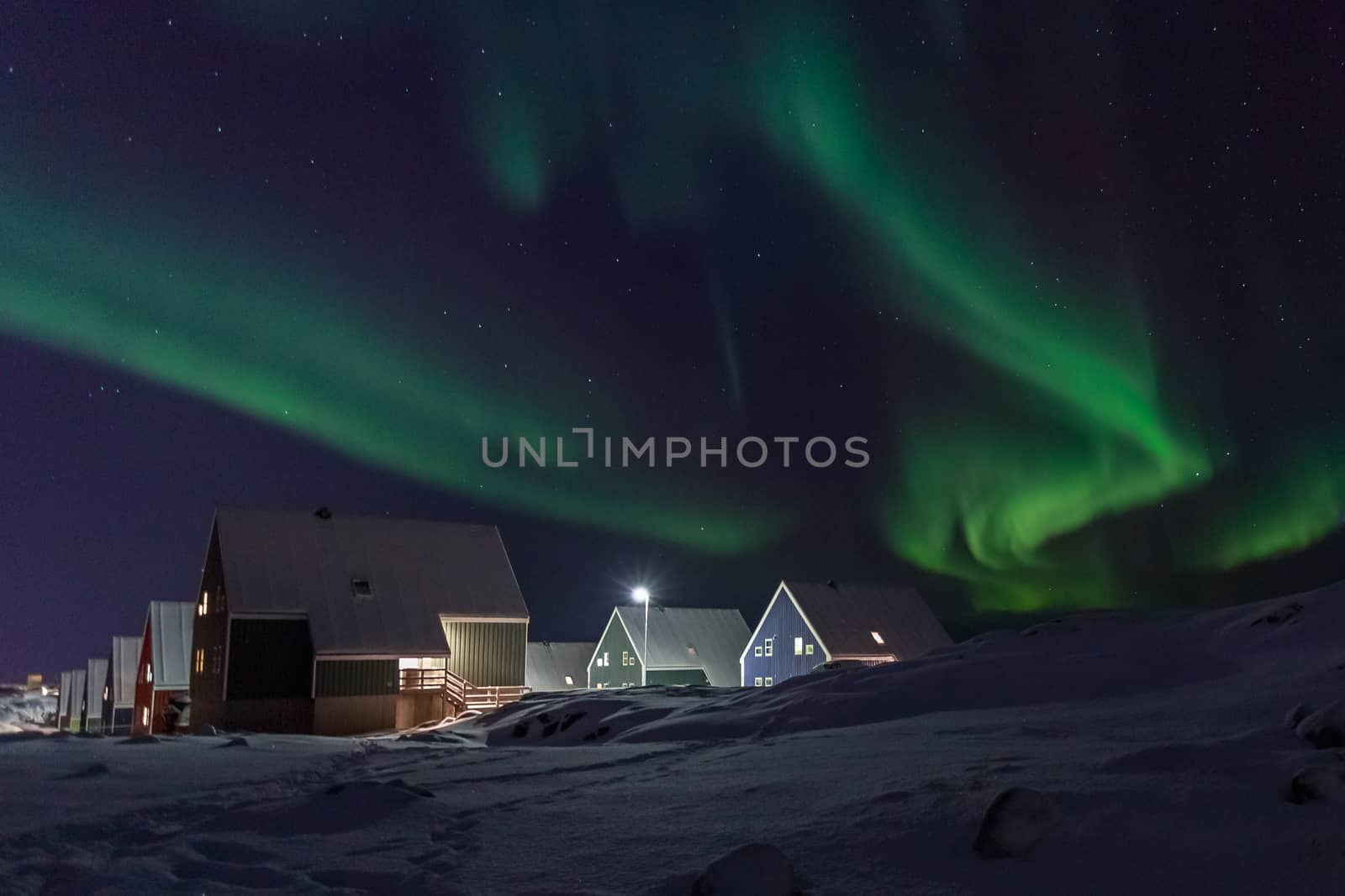 Arctic village and green waves of Northern lights over Inuit hou by ambeon