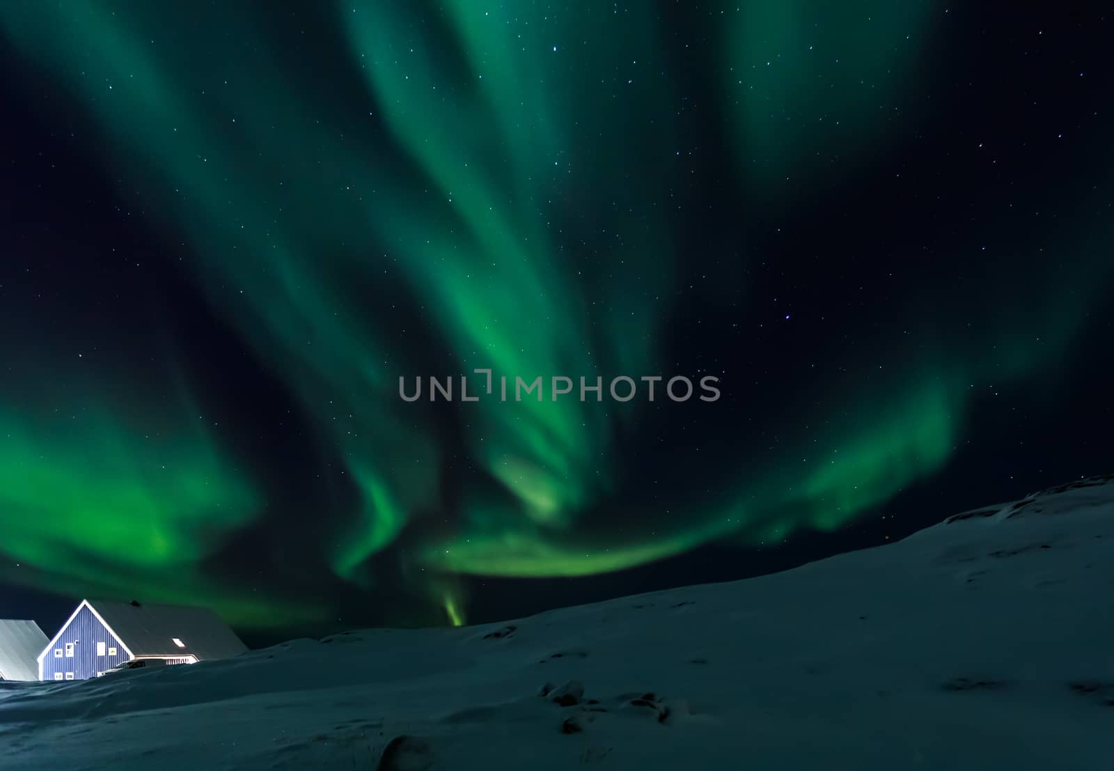 Arctic village and green waves of Northern lights over Inuit hou by ambeon