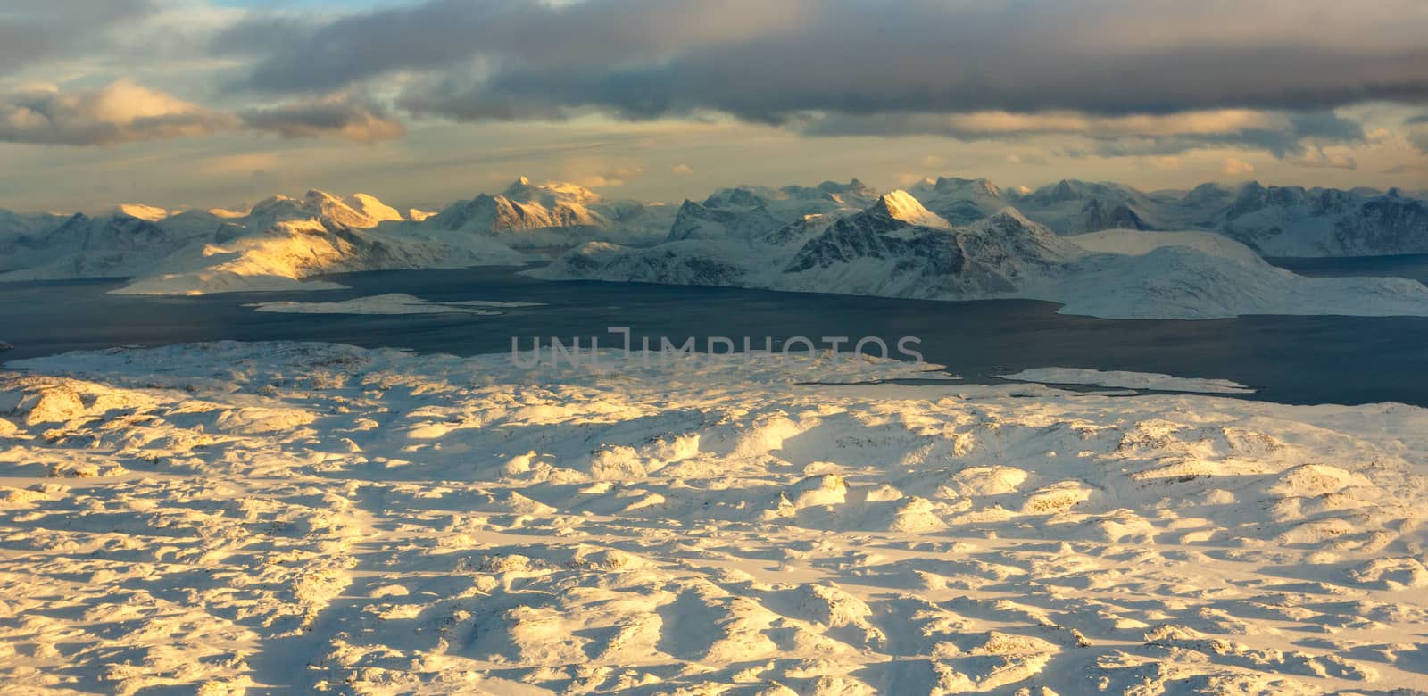 Greenlandic ice cap with wrozen mountains and fjord aerial view, by ambeon