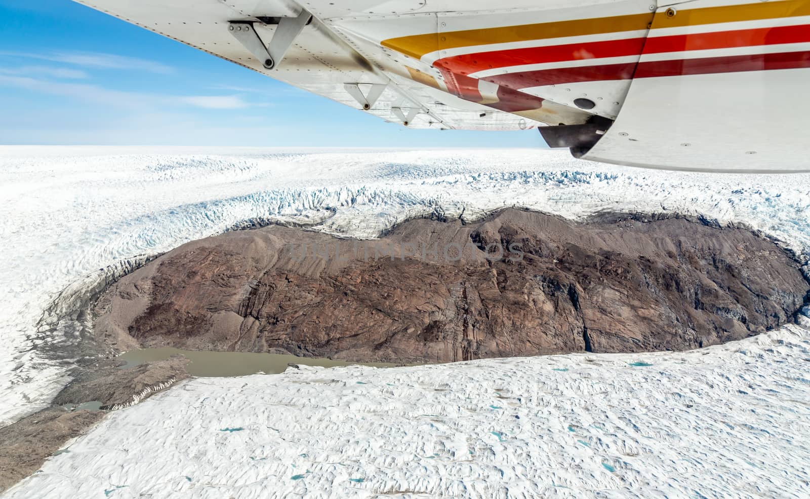 Greenlandic melting ice sheet glacier aerial view from the plane by ambeon