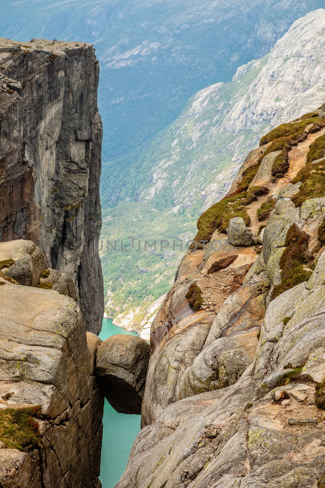 Kjeragbolten, view from the top to the stone stuck between two rocks with fjord in the background, Lysefjord, Norway