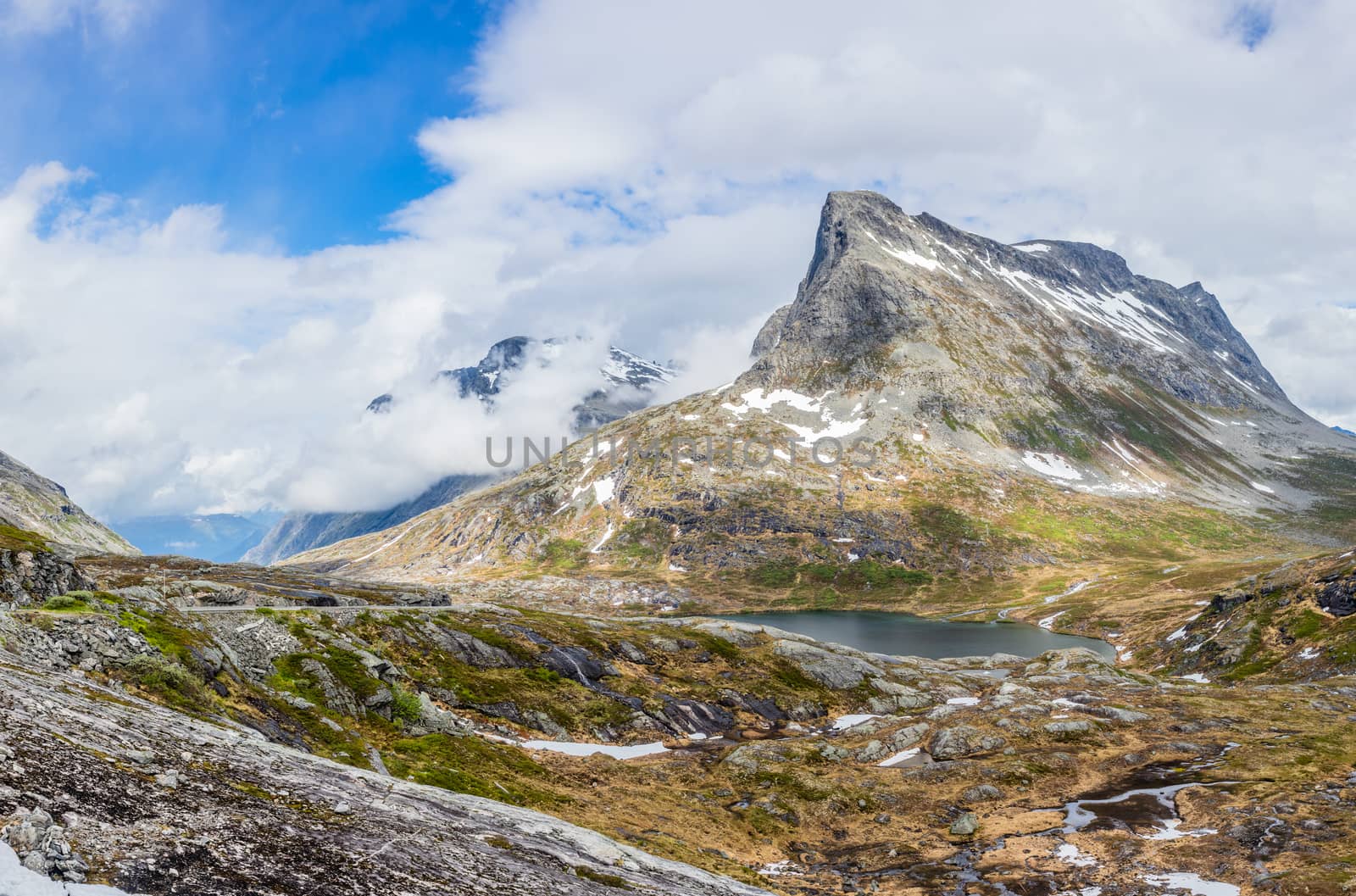 Passage in the mountains with snowy peaks around Alnesvatnet lak by ambeon