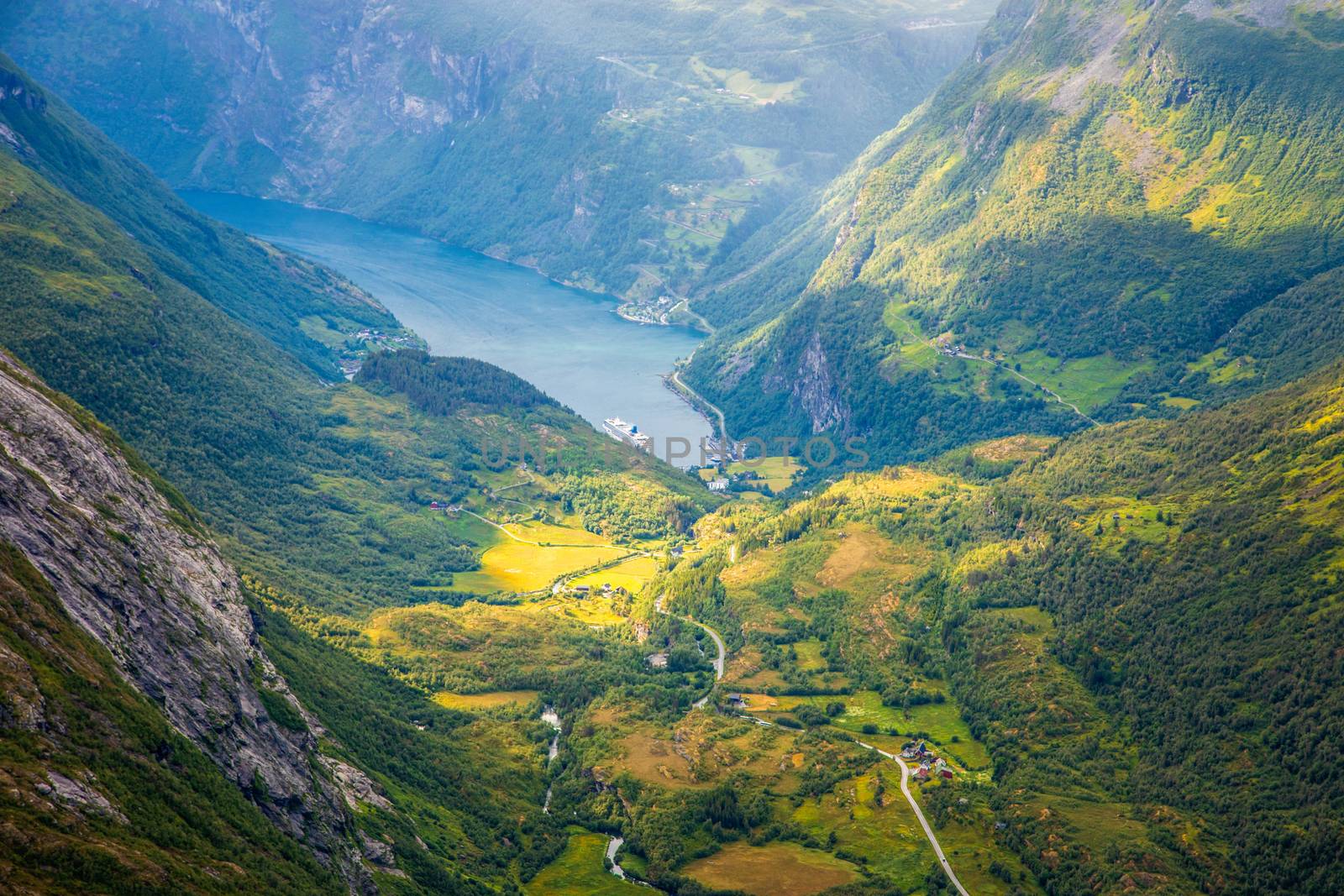 View to the Geiranger fjord with green valley surrounded by moun by ambeon