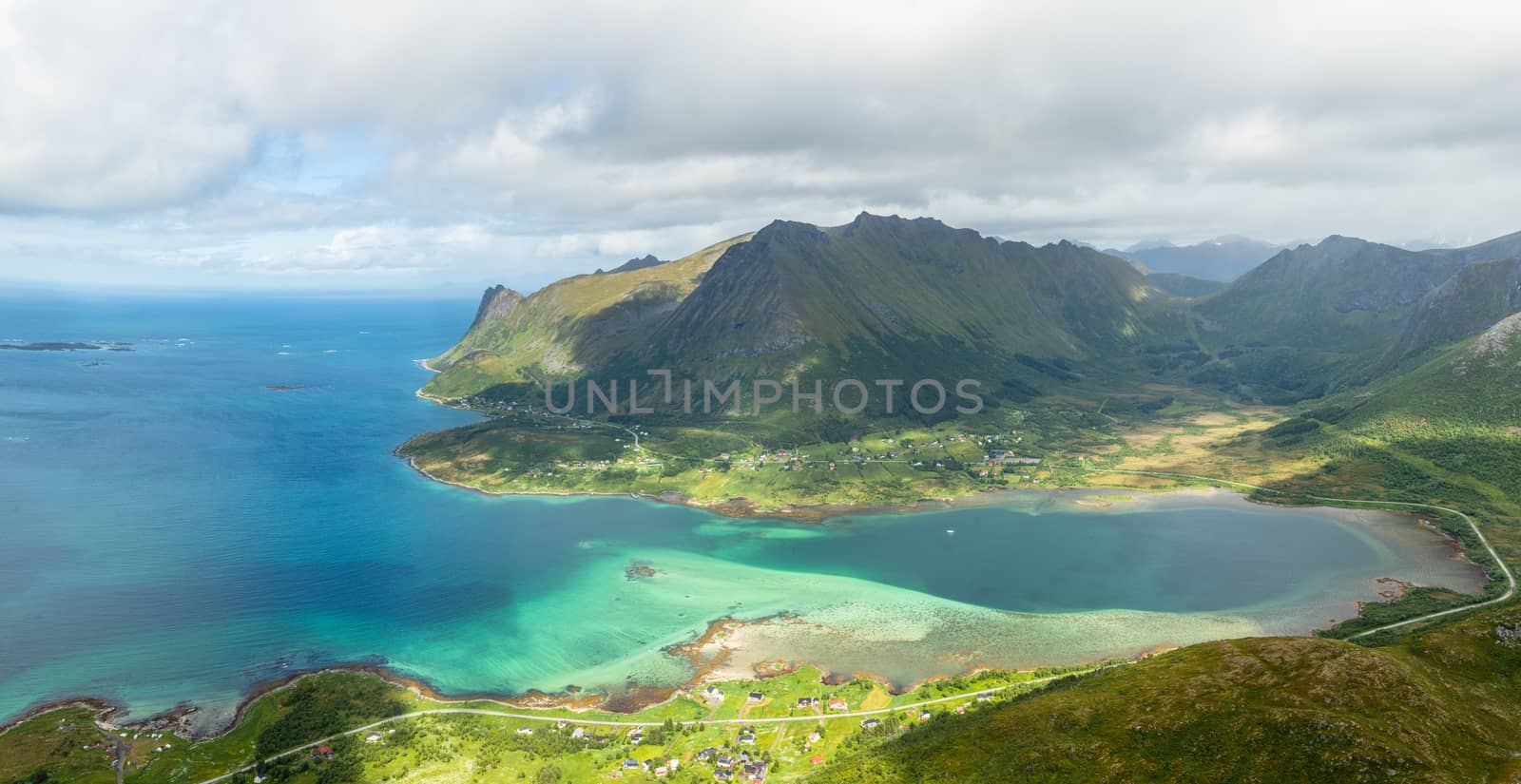 View from the top of Kleppstadheia mountain to the bay with turquoise water, and Rystad and Toe  villages on the shores Austvagoya, Lofotens, Norway
