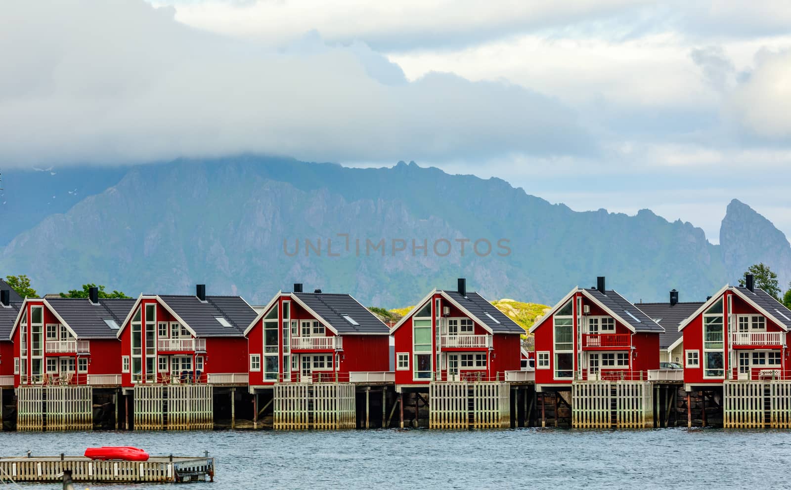 Red norwegian fishing houses rorbu at pier in Svolvaer, Lototen  by ambeon