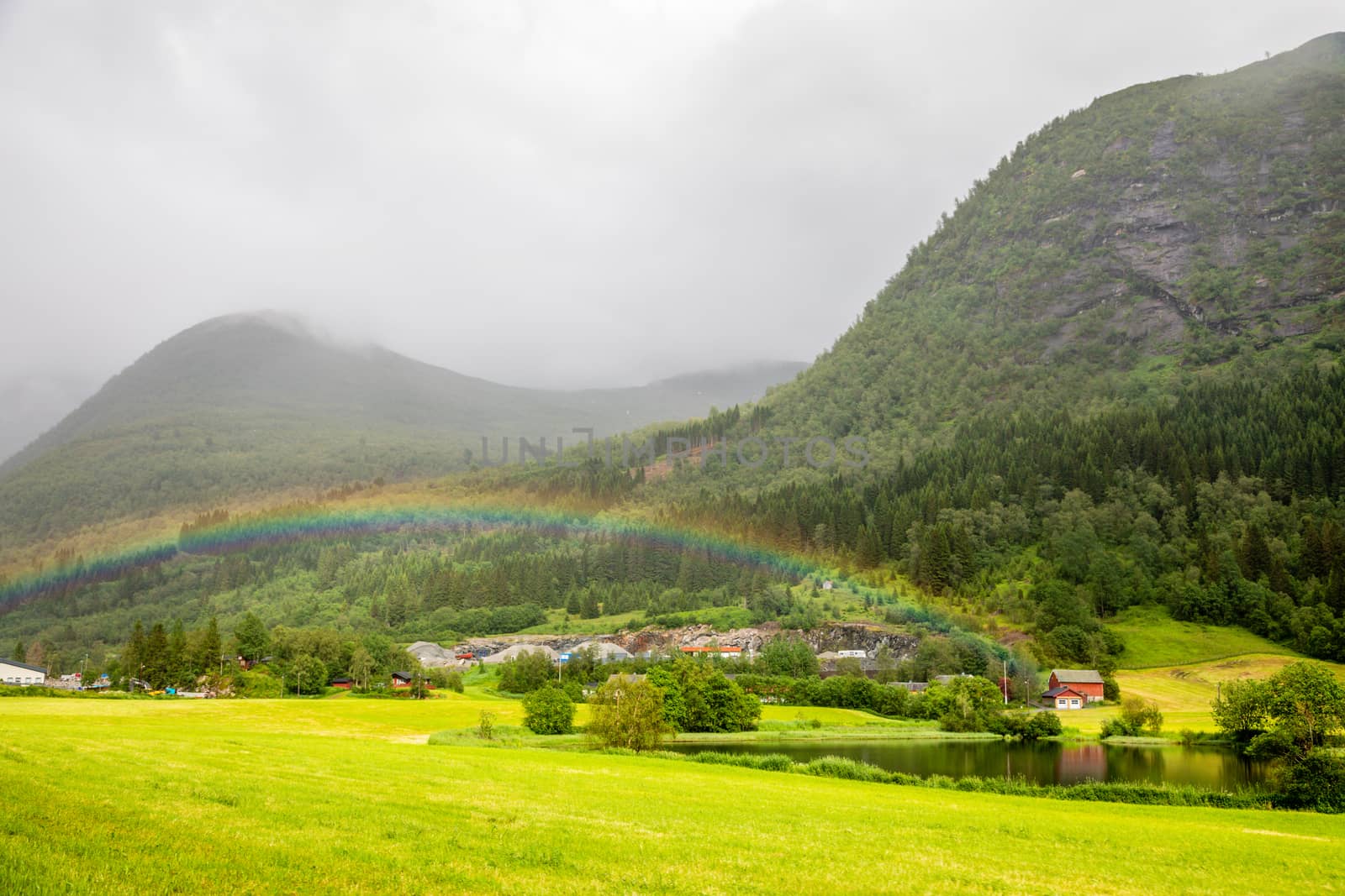 Colorful rainbow over the fields, lake and houses of Skei village, Jølster in Sogn og Fjordane county, Norway.