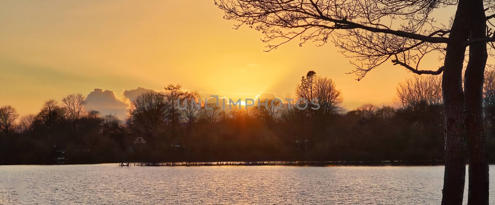 Beautiful and romantic sunset at a lake in stunning yellow and orange colors