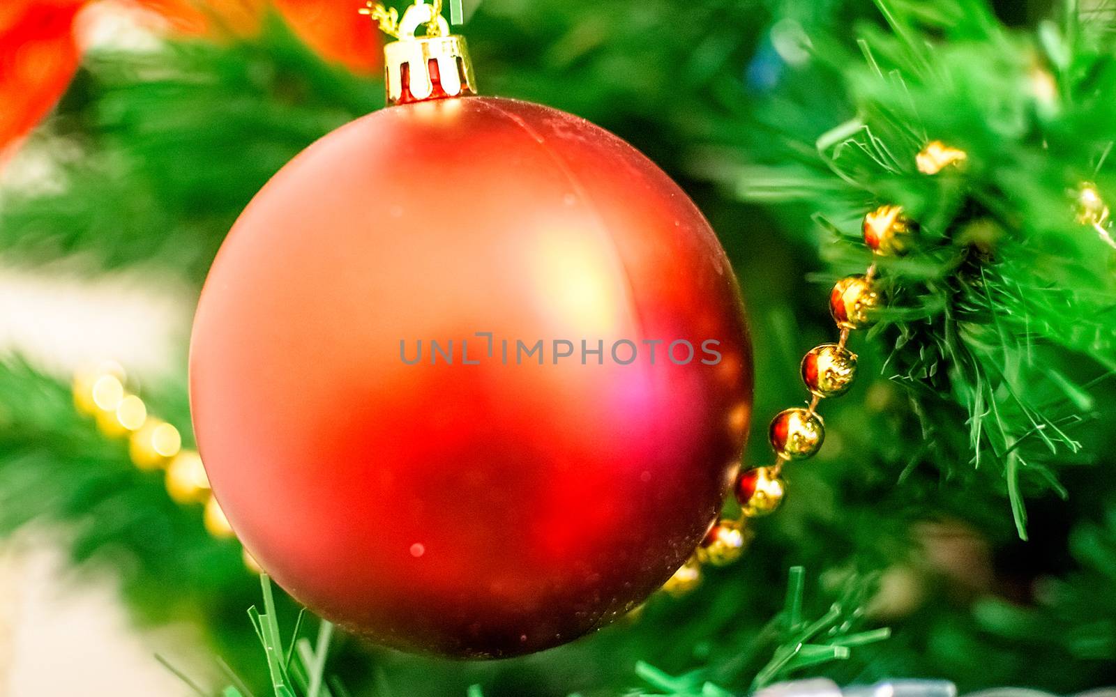 Christmas red ball on a branch with beautiful blur. Intentionally shallow dept of field