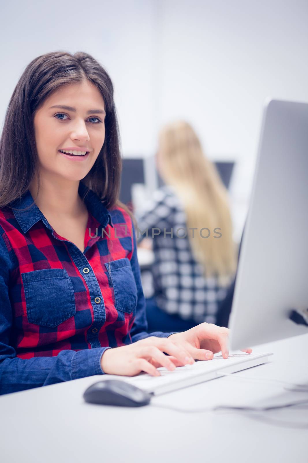 Smiling student working on computer at university 