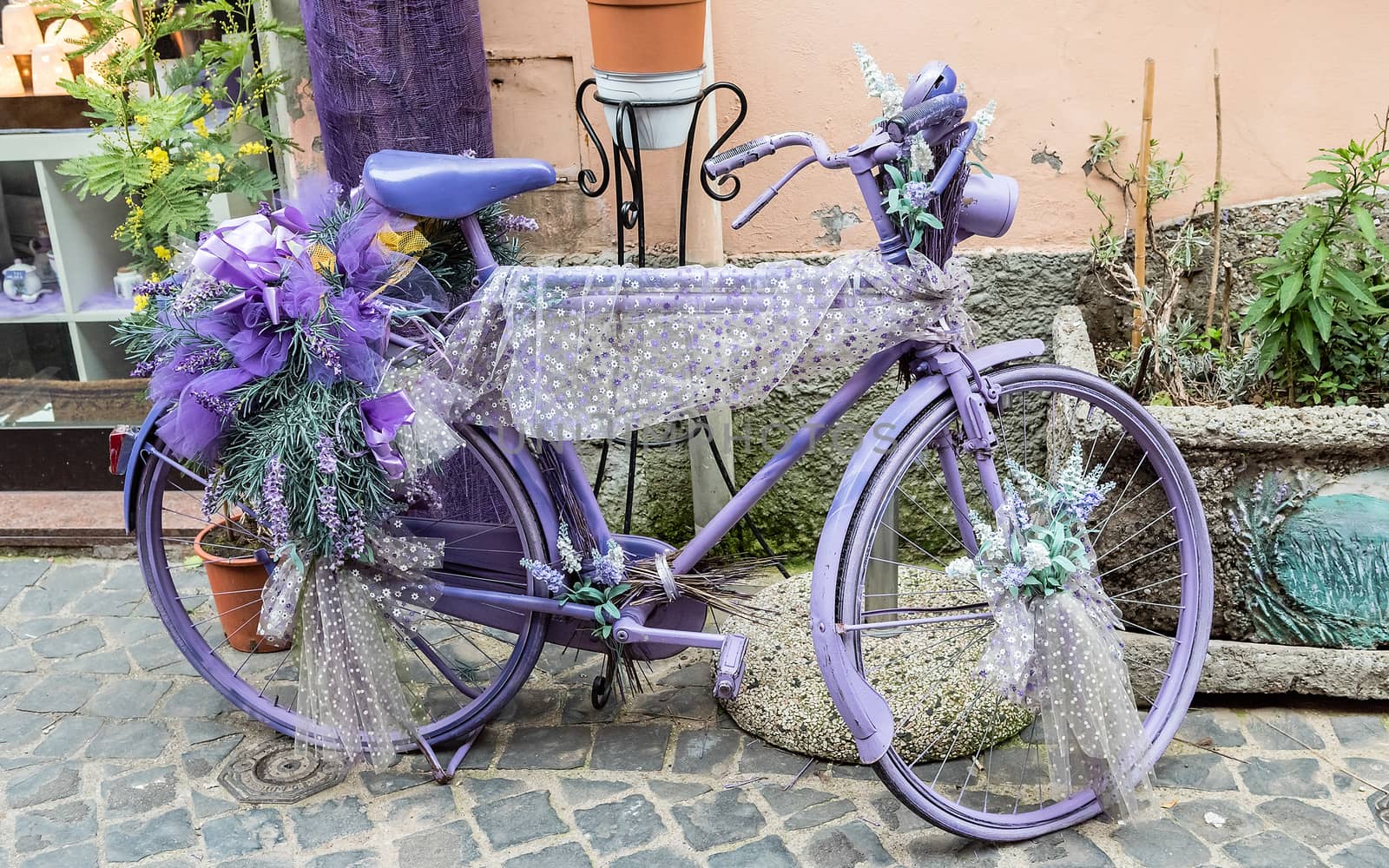 Vintage violet bicycle decorated with flowers and laces