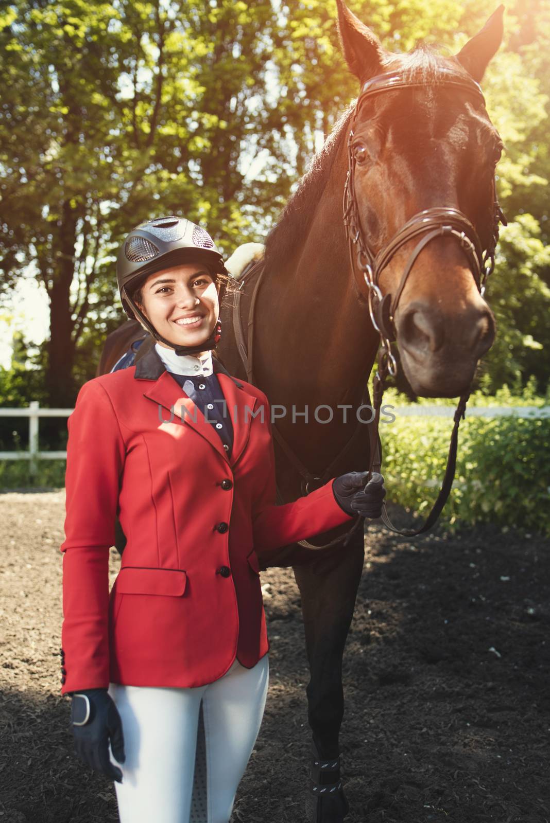 A young girl takes care of her horse. She loves the animals and joyfully spends her time in their environment.