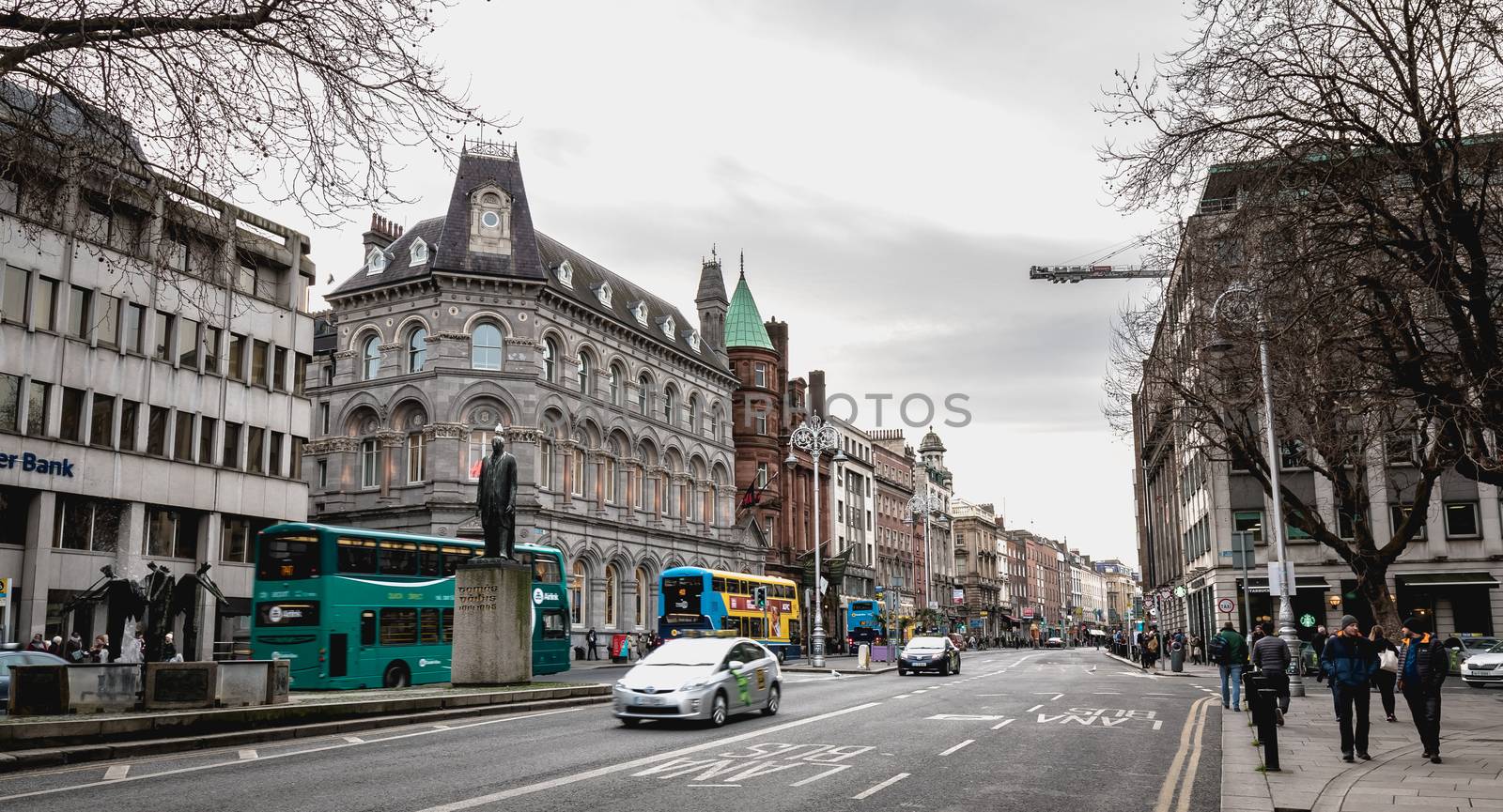 Dublin, Ireland - February 11, 2019: People walking down a shopping street with typical Irish architecture in the historic city center on a winter day
