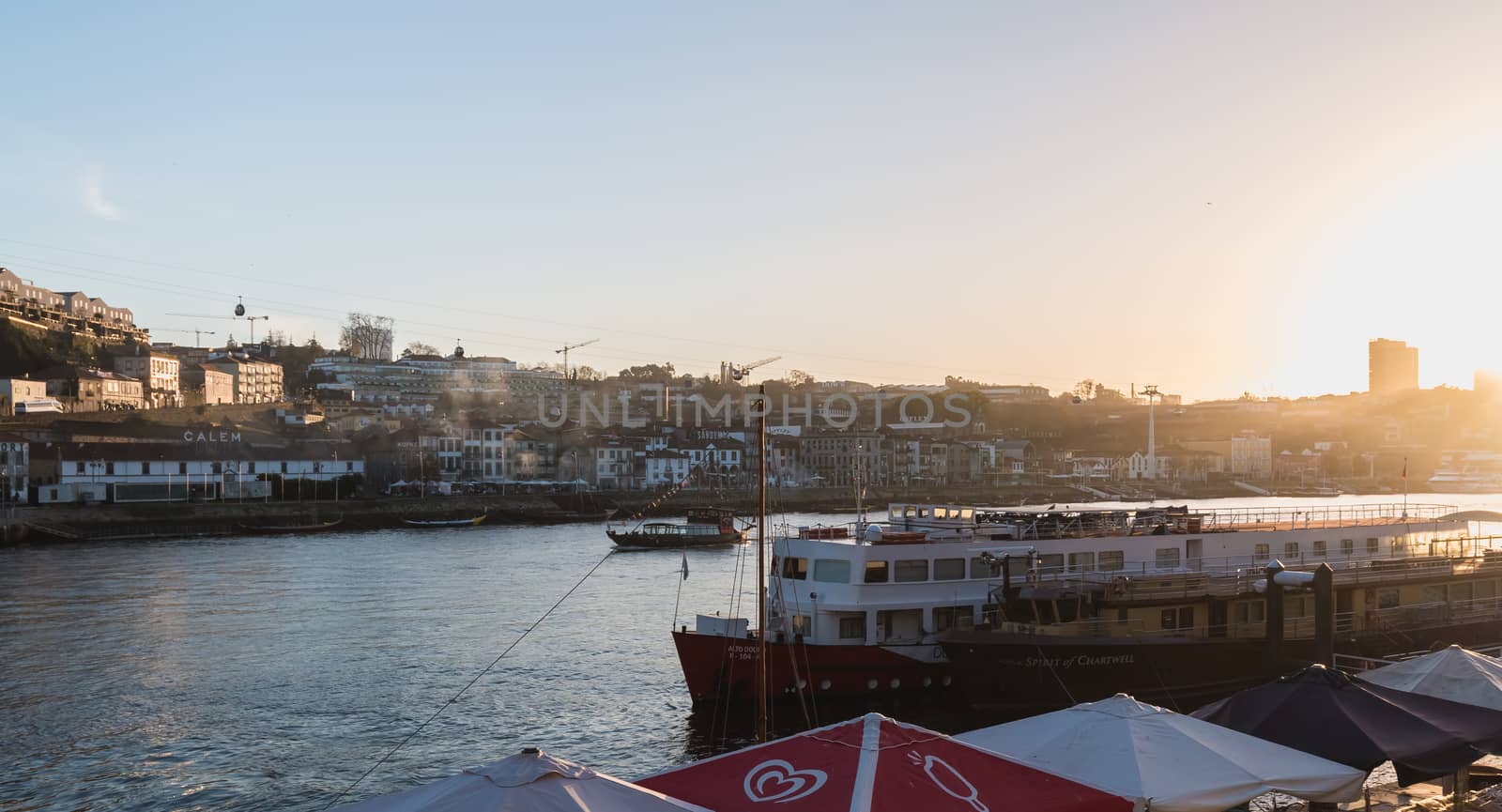 Porto, Portugal - November 30, 2018: Street atmosphere near the Dom Luiz bridge with its café terrace and its traders where people are walking on an autumn day