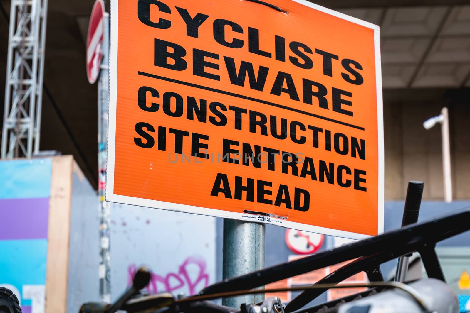 Dublin, Ireland - February 16, 2019: Cyclists Beware - Construction site entrance ahead - on a street sign in the city center on a winter day