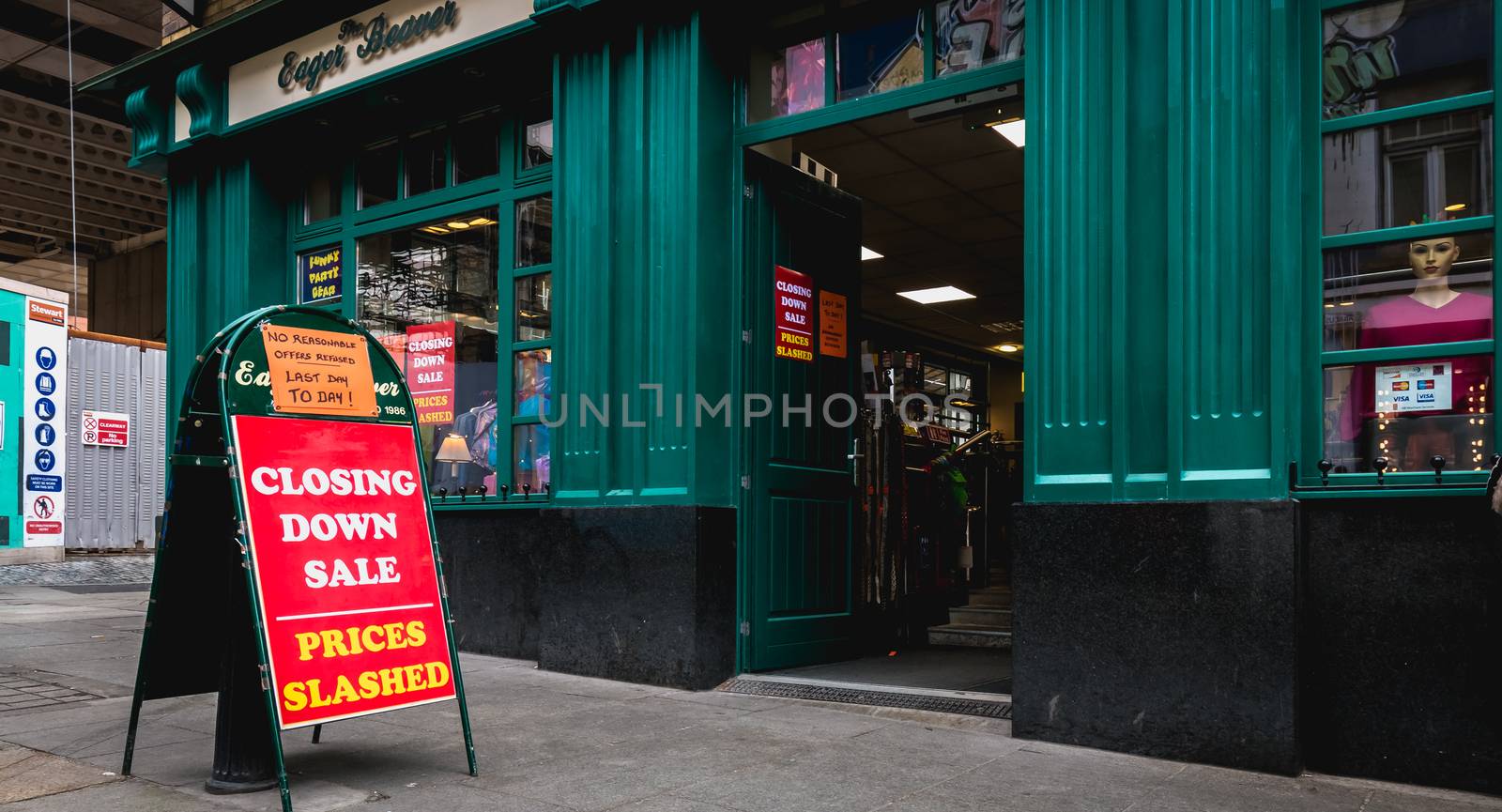 Dublin, Ireland - February 16, 2019: Closing Down Sale - Prices Slashed - No reasonable offers refused - Last day to day - on a street sign outside a city center store on a winter day