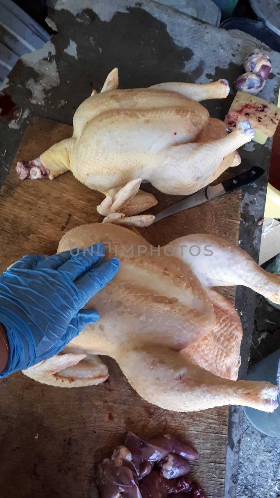 Cutting the broiler carcass on the cutting board. Homemade chicken.