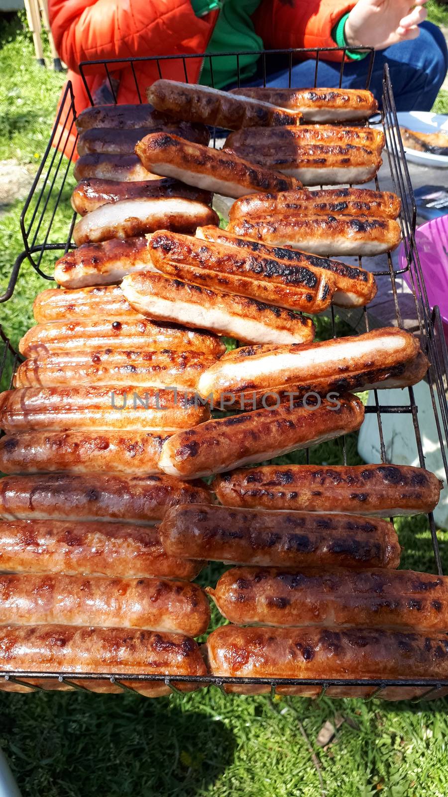 Grilled sausages on a grid. Barbecue in the backyard.