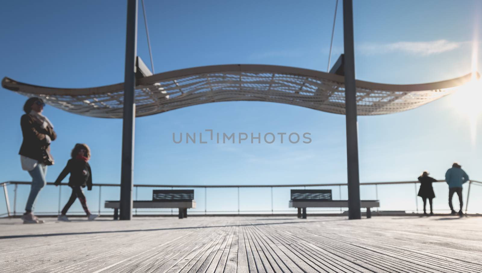 Agde, France - January 01, 2019: street atmosphere of the quays of the port of Agde where people are walking on a winter day