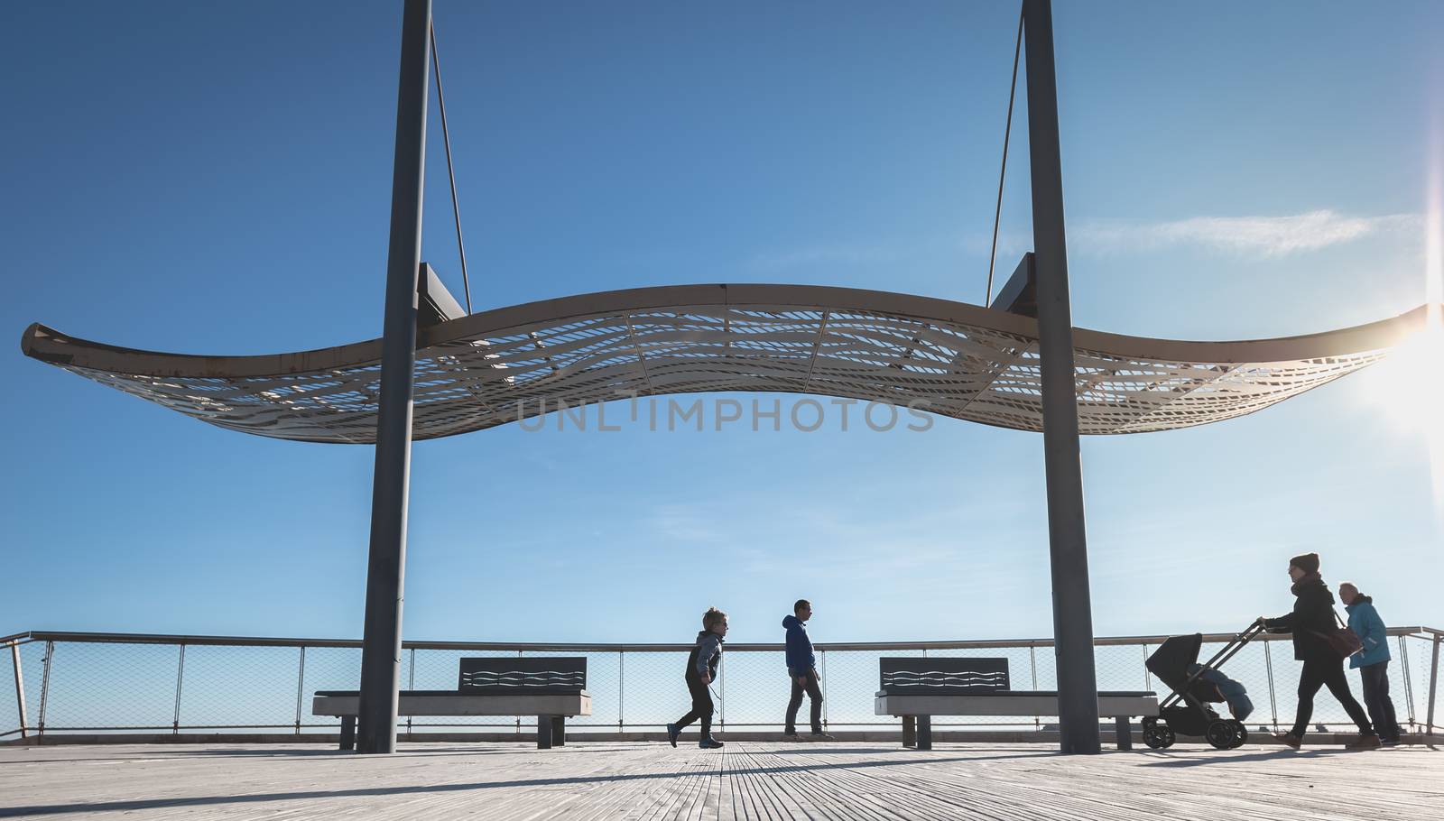 Agde, France - January 01, 2019: street atmosphere of the quays of the port of Agde where people are walking on a winter day