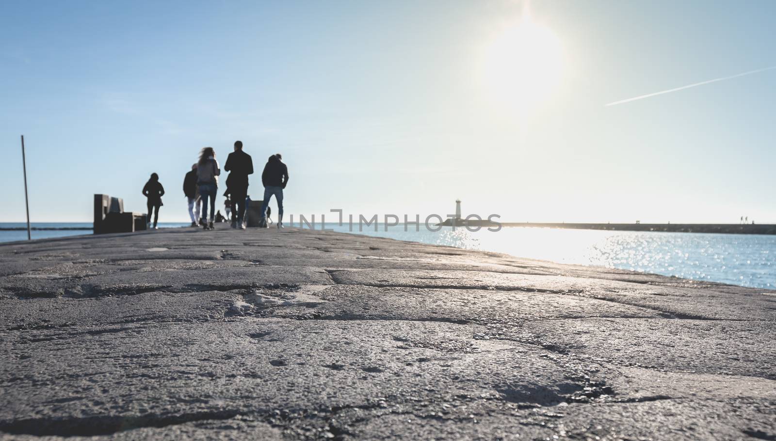 Agde, France - January 01, 2019: street atmosphere of the quays of the port of Agde where people are walking on a winter day