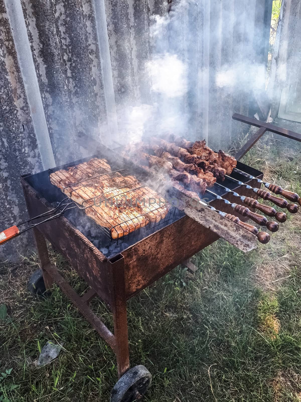 Steel barbecue trolley. convenient barbecue. frying meat on the grill.