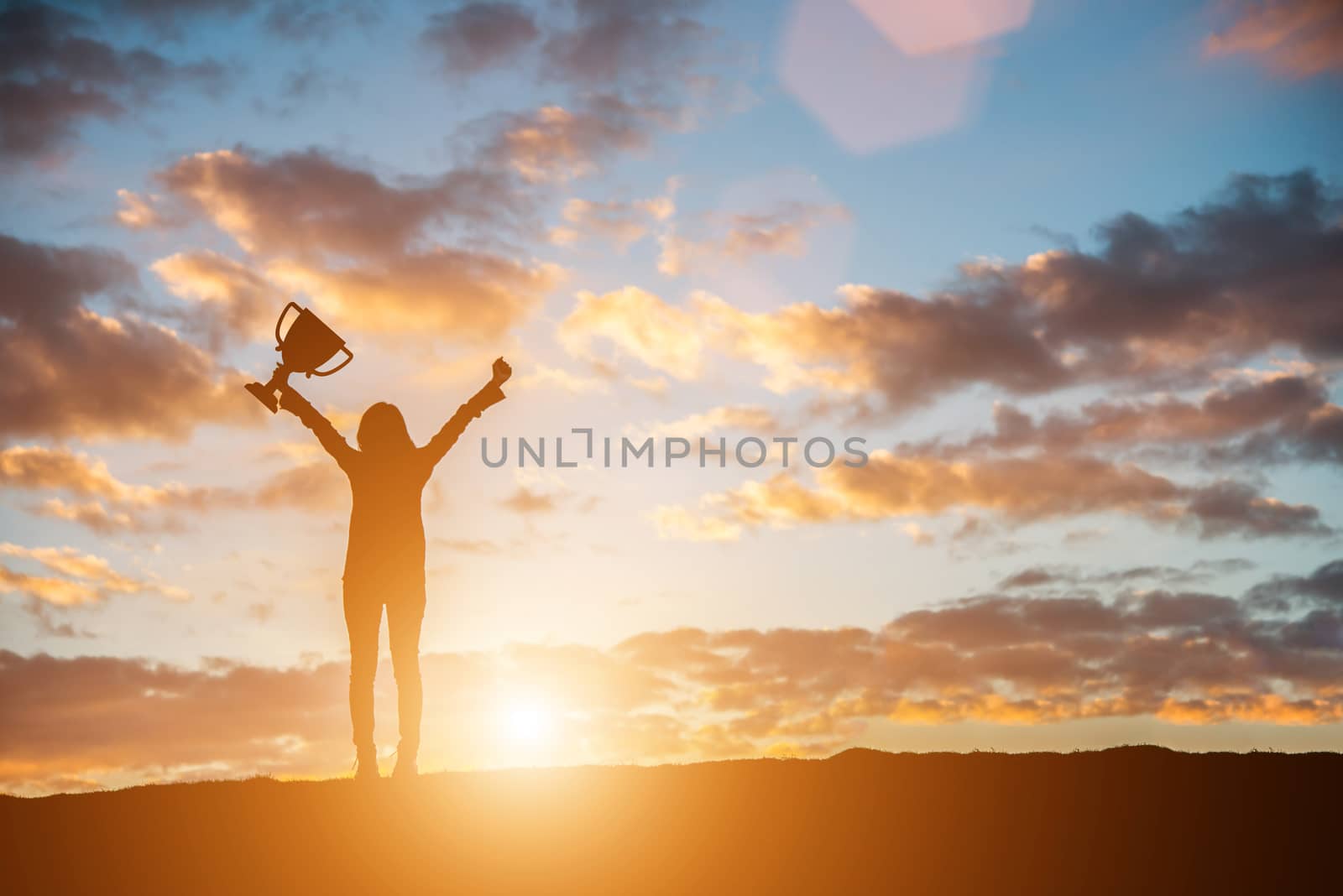 Happy celebrating winning success woman at sunset. Silhouette of young woman with bouquet in hand.