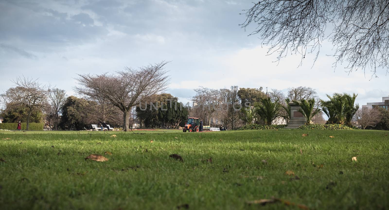 Dublin, Ireland - February 13, 2019: Gardeners moving by tractor on the lawns of Phoenix Park near the historic city center on a winter day