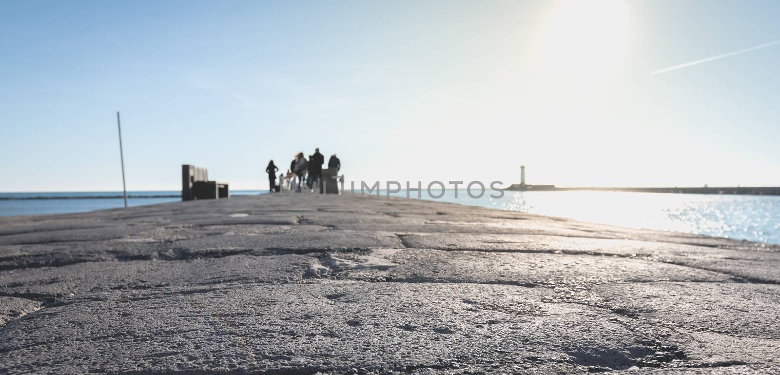 Agde, France - January 01, 2019: street atmosphere of the quays of the port of Agde where people are walking on a winter day