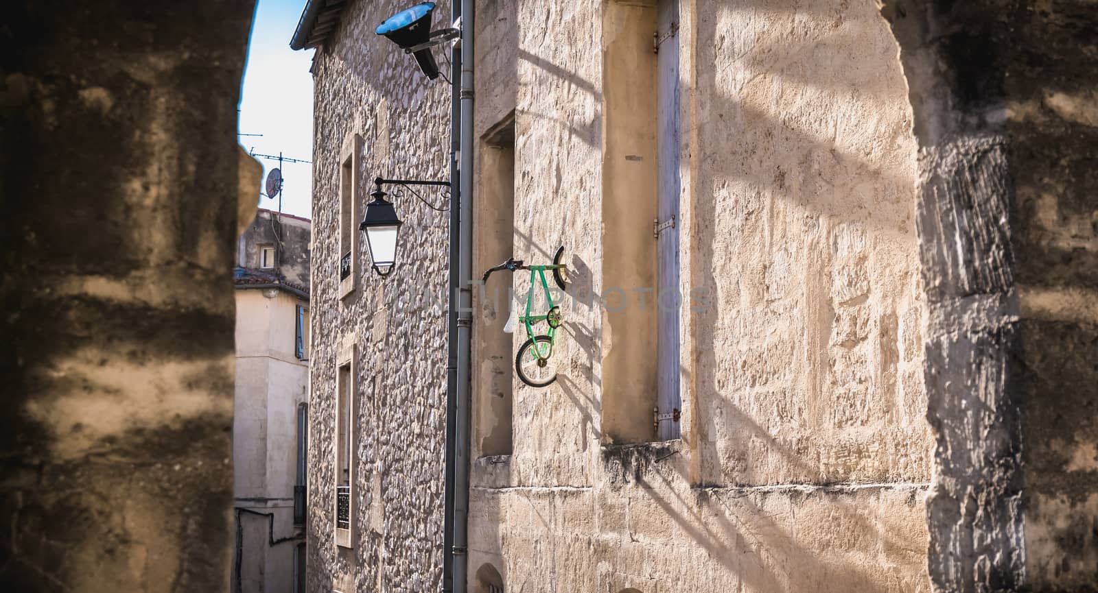 bike hanging on a wall in the historic city center of Montpellie by AtlanticEUROSTOXX