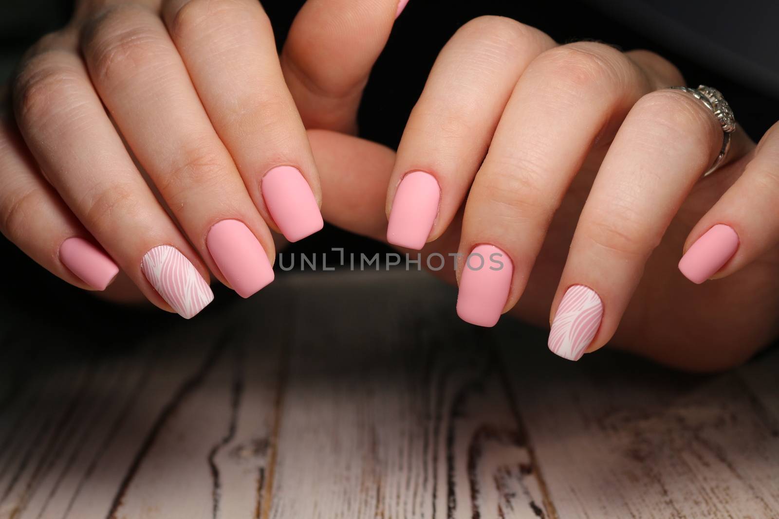 Closeup photo of a beautiful female hands with elegant manicure and diamond rings.