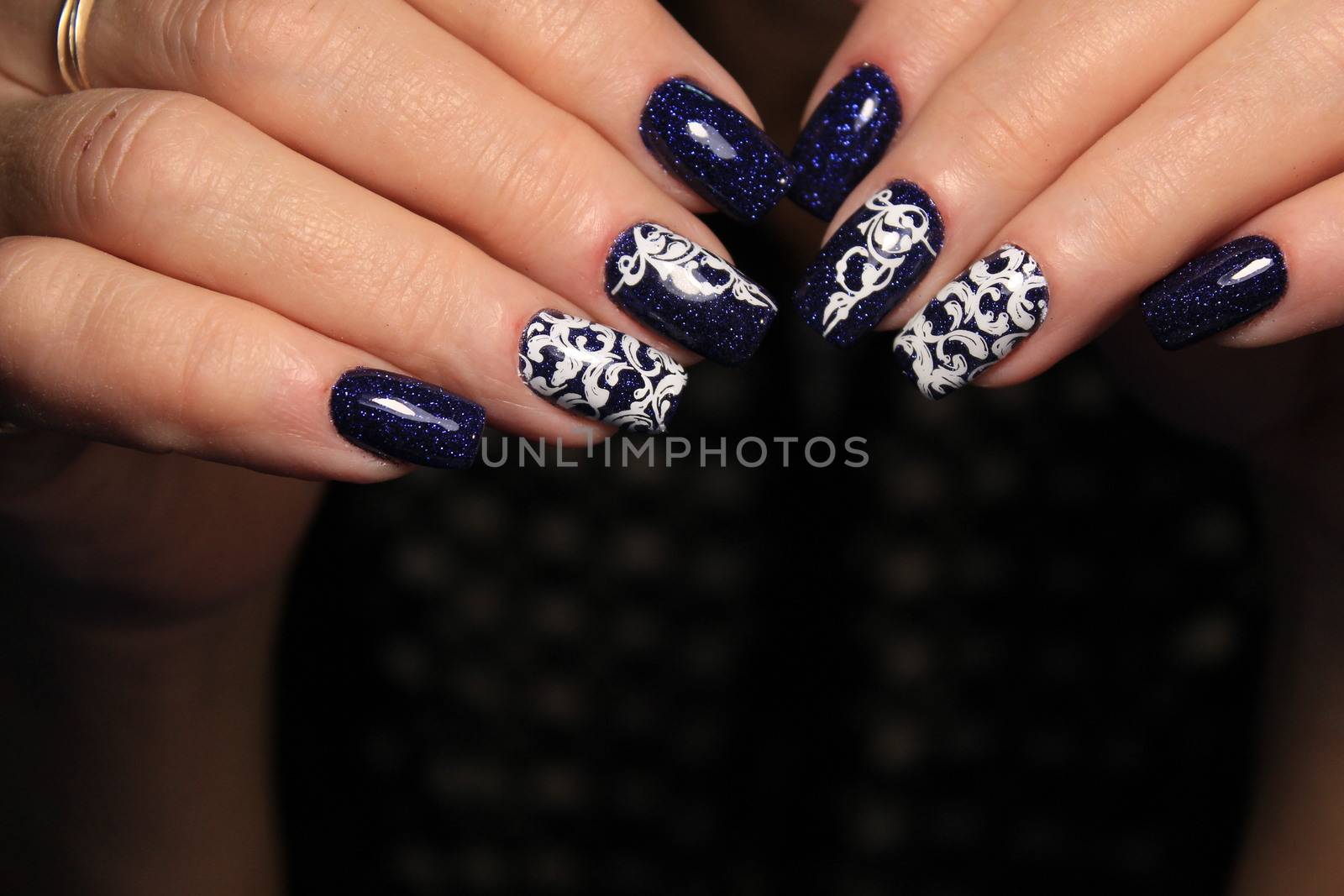 Closeup photo of a beautiful female hands with elegant manicure and diamond rings.