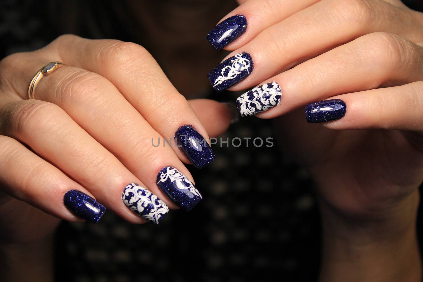 Closeup photo of a beautiful female hands with elegant manicure and diamond rings.