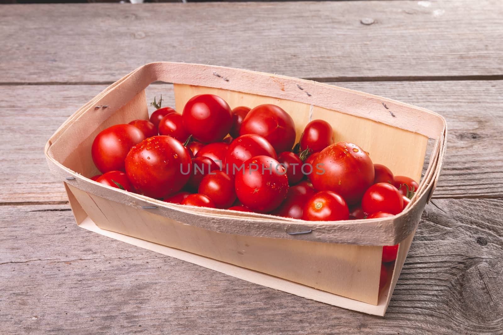 ripe tomatoes in a small wooden crate by AtlanticEUROSTOXX
