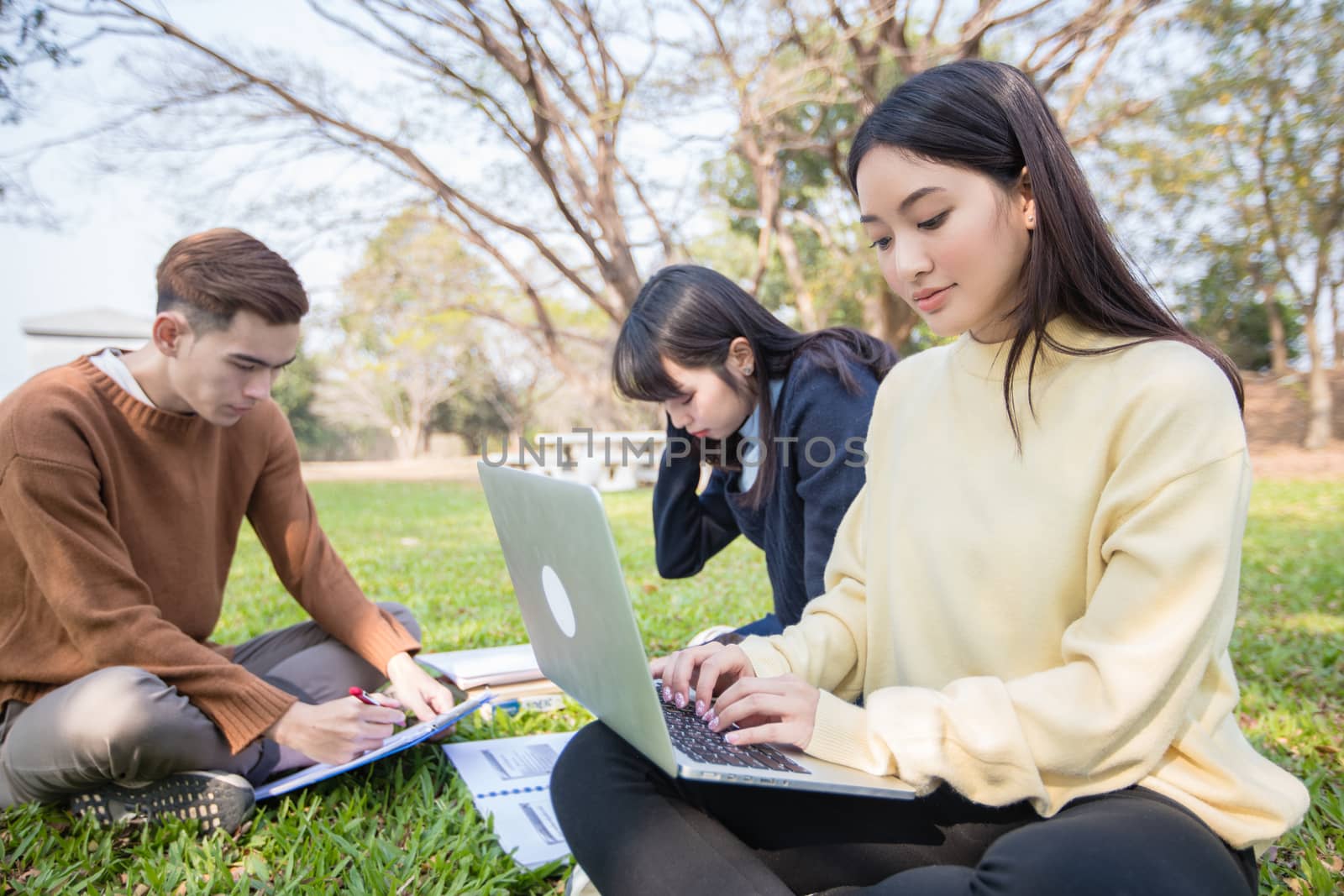 Asian students use notebook computers and tablet to work and study online in garden at home during the coronavirus epidemic and quarantine at home by Tuiphotoengineer