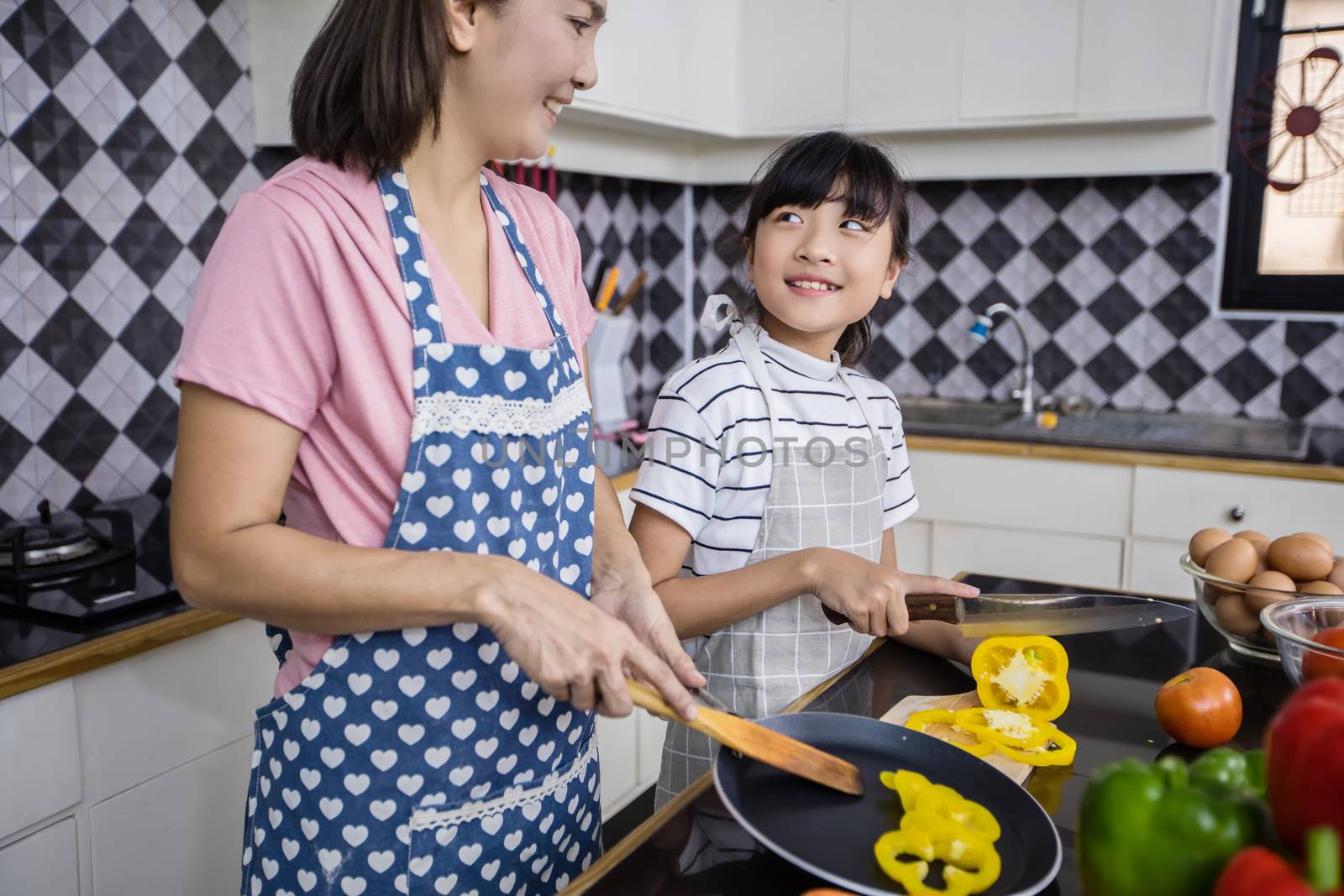 Asian families are cooking  and parents are teaching their daughters to cook in the kitchen at home.  Family activities on holidays and Happy in recreation concept by Tuiphotoengineer