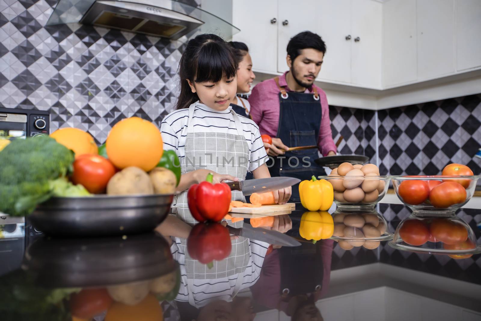 Asian families are cooking  and parents are teaching their daughters to cook in the kitchen at home. 
Family activities on holidays and Happy in recreation concept