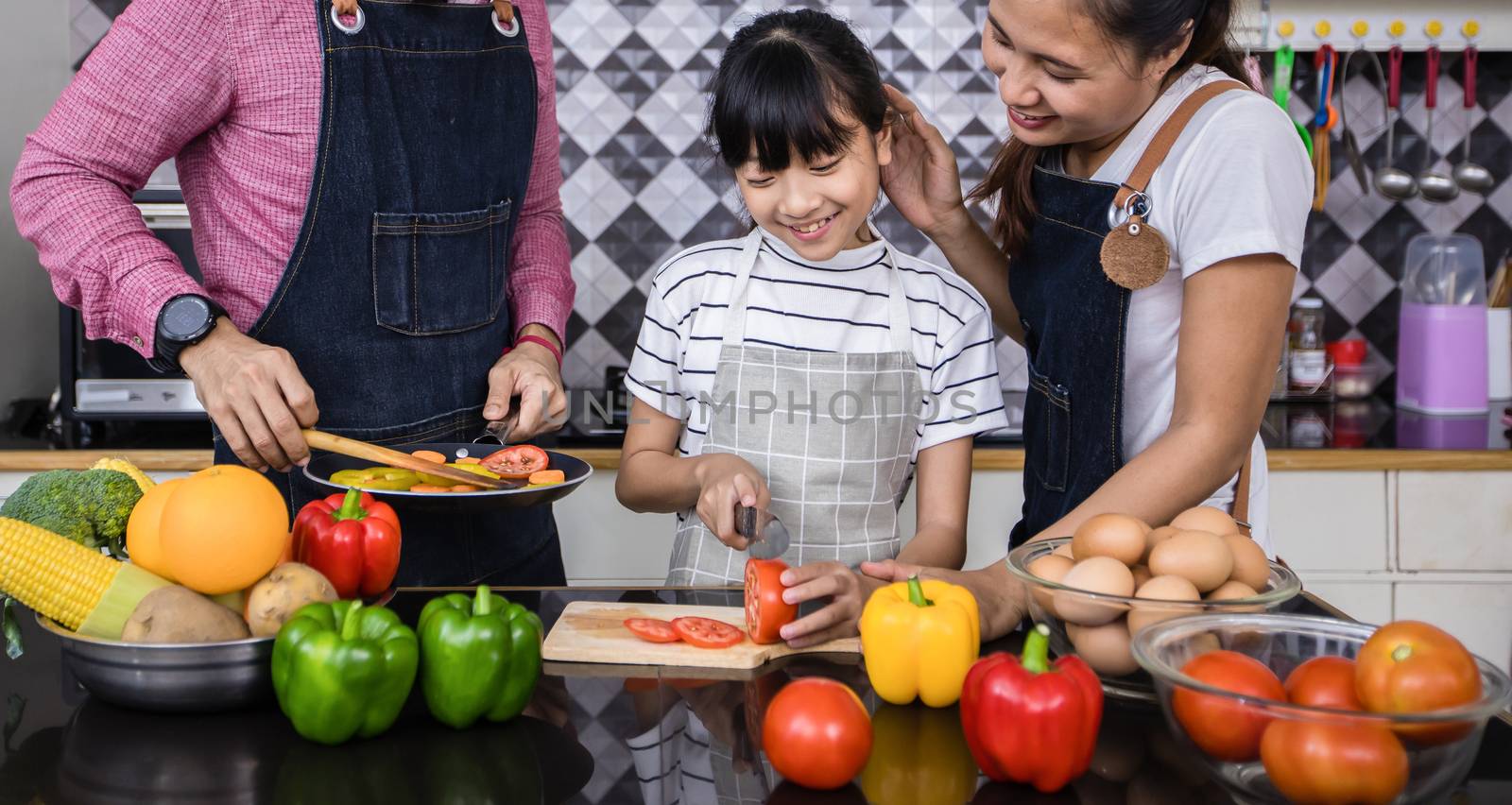 Asian families are cooking  and parents are teaching their daughters to cook in the kitchen at home. 
Family activities on holidays and Happy in recreation concept