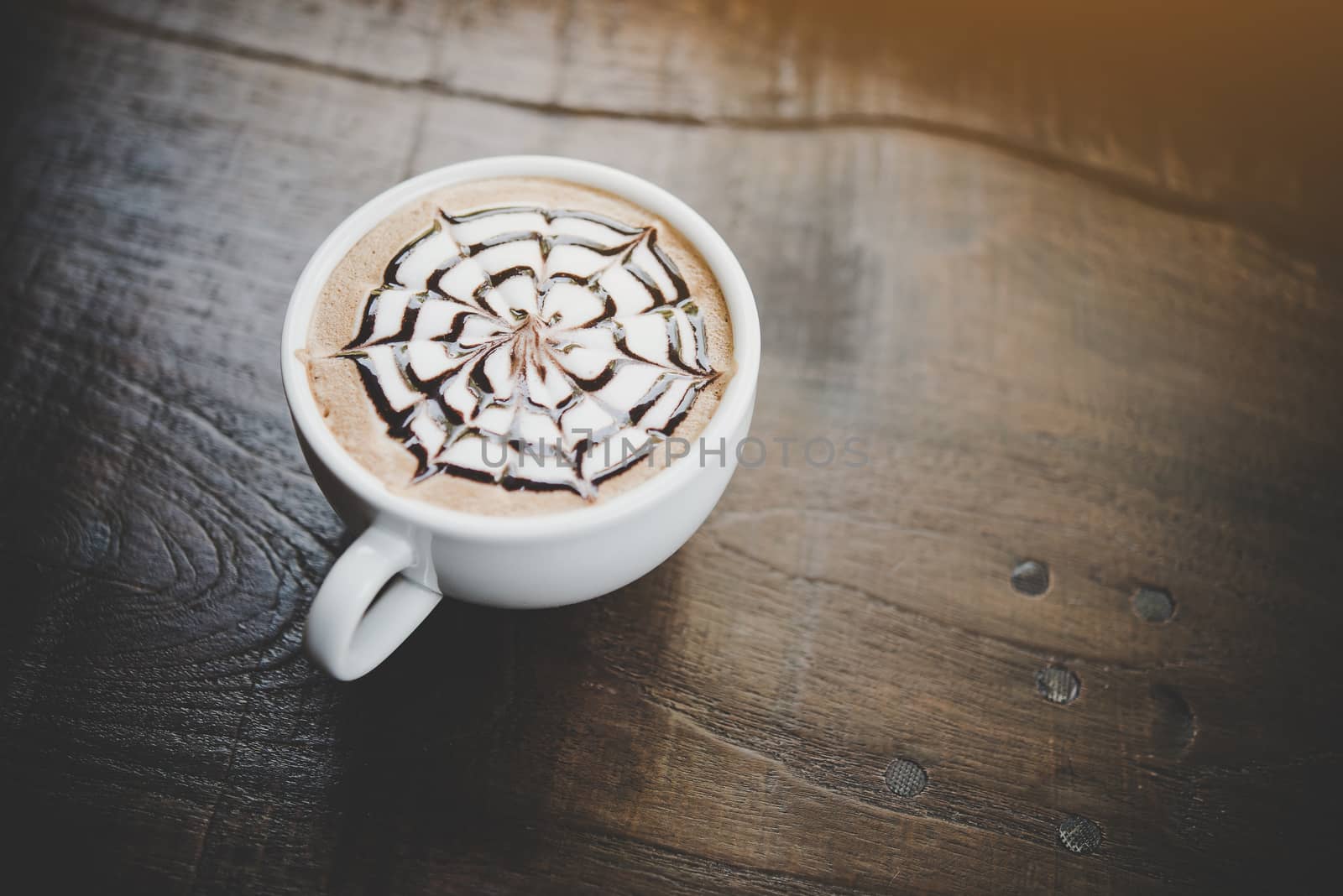 A cup of coffee on wooden table in cafe.