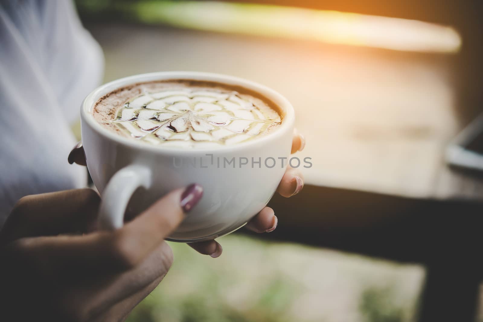 Woman's hand holding a cup of coffee. Enjoy with coffee in the morning.