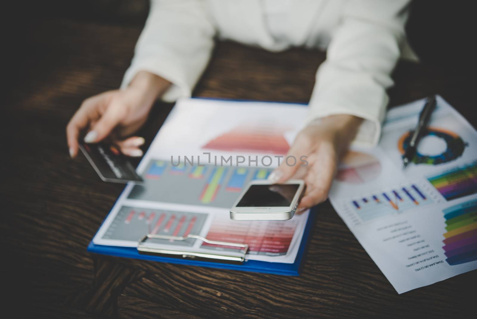 Woman holding credit card and using smart phone for online shopping with vintage tone.