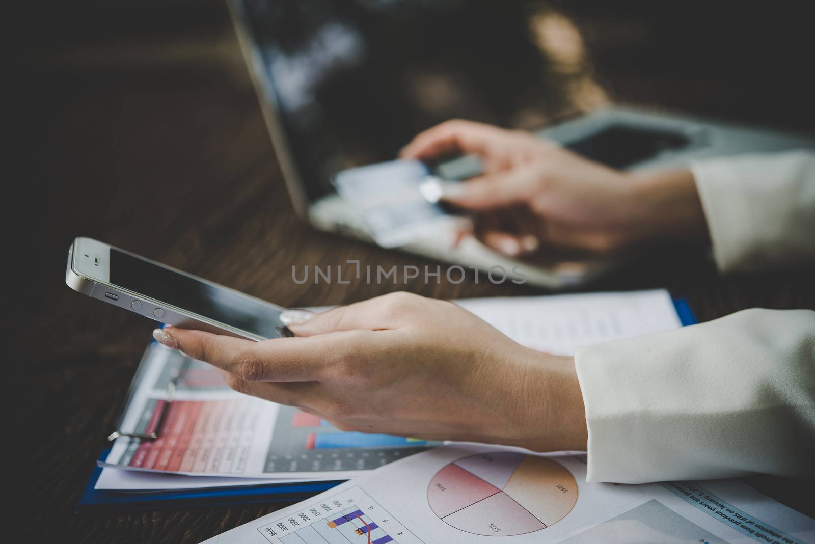 Woman holding credit card and using smart phone for online shopping with vintage tone.