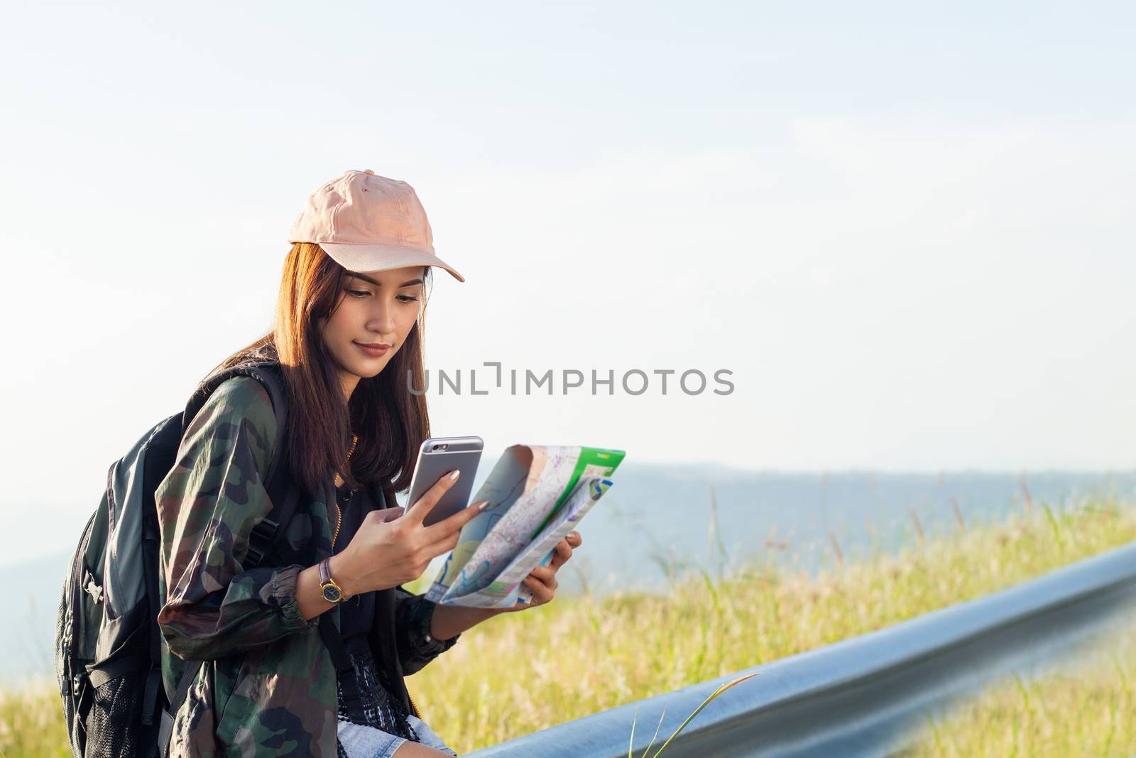 women asian with bright backpack looking at a map. View from bac by Tuiphotoengineer