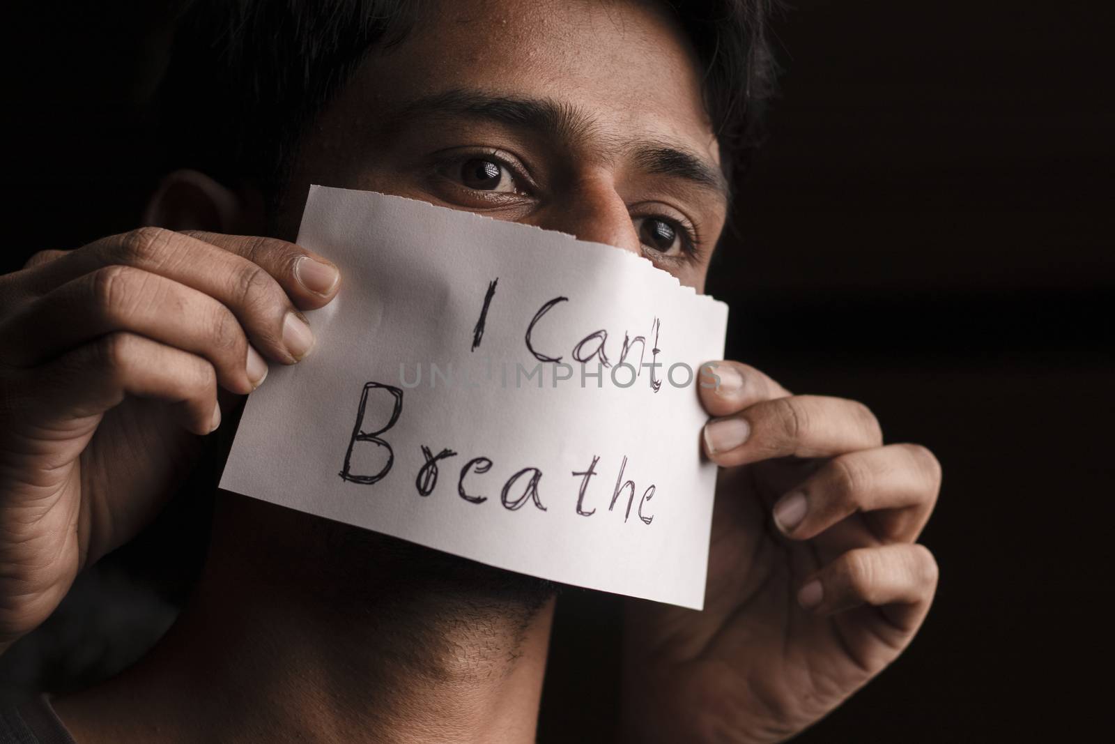 Man covered his face with text I cant breathe in Dark background - concept of protest against the racial discrimination