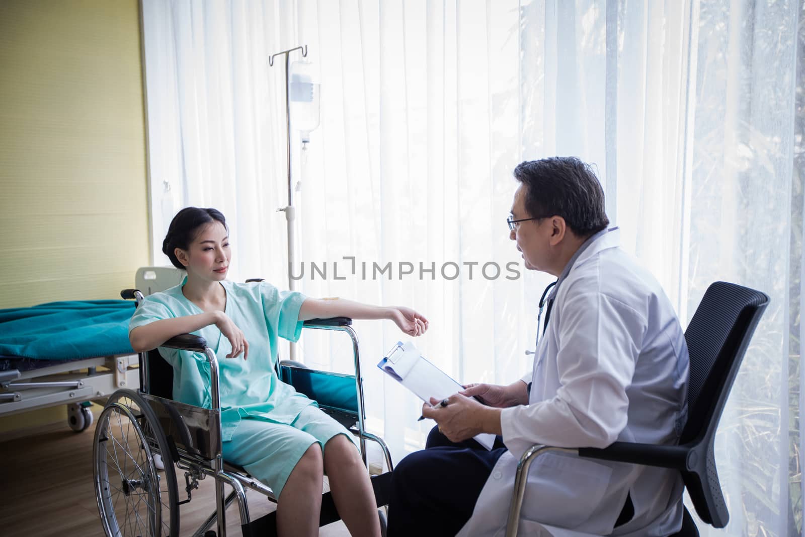 The doctors are asking and explaining about the illness to a female patient lying in bed at a hospital.