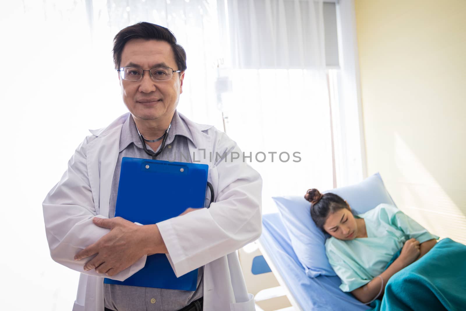 The doctors are asking and explaining about the illness to a female patient lying in bed at a hospital.
