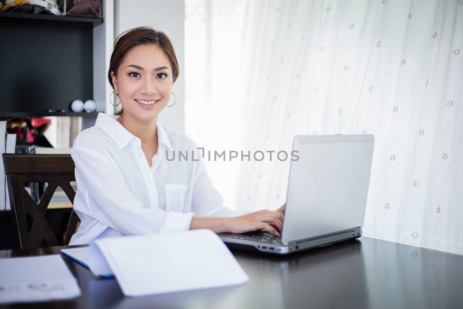 beautiful Asian business women checking document and using notebook and smiling happy for working