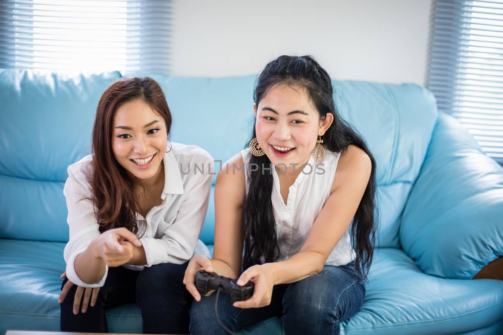 two women Competitive friends playing video games and excited happy cheerful at home