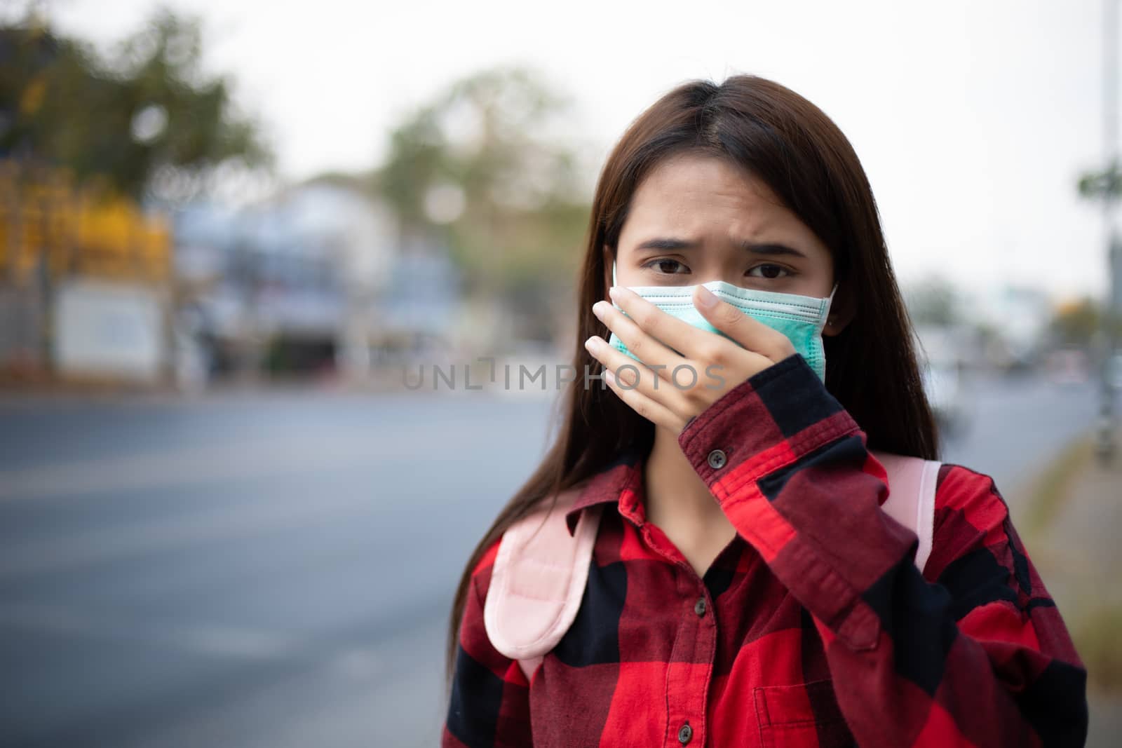 Asian Young woman walking in the city wearing face mask because of air pollution, particulates and for protection flu virus, influenza, coronavirus