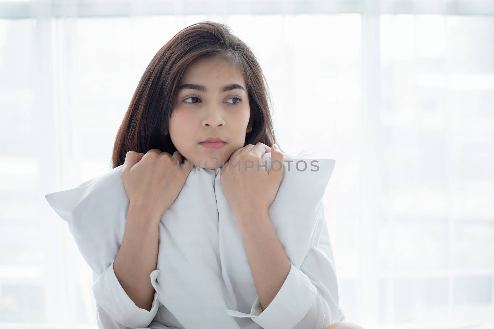 Asian woman Beautiful young smiling woman sitting and sleeping in white bed and stretching in the morning at bedroom after waking up in her bed fully rested